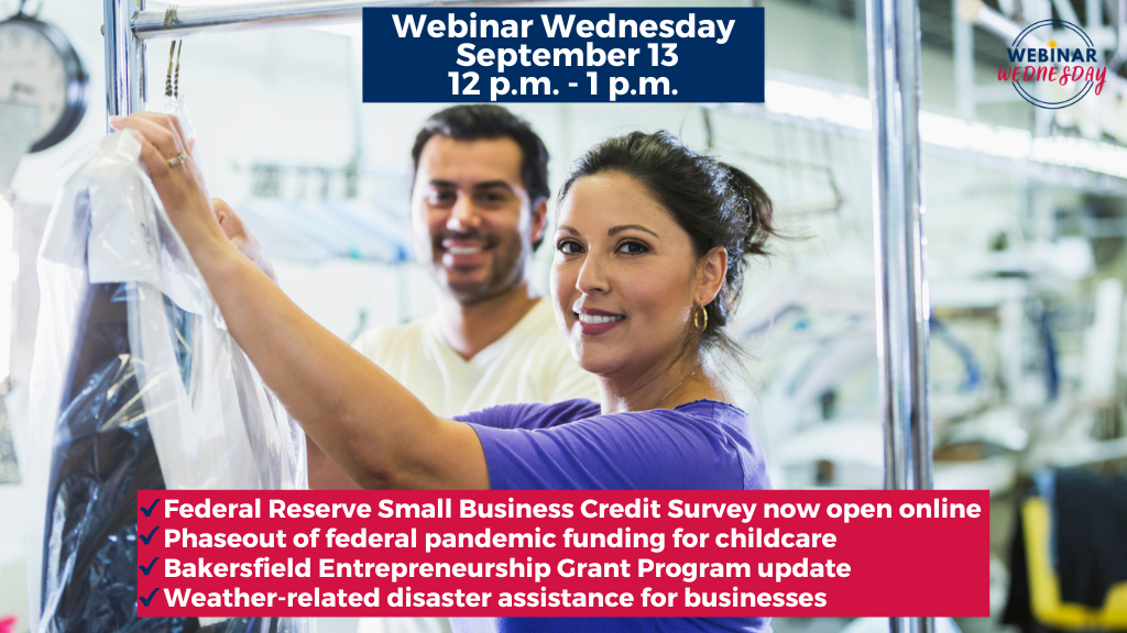 A woman and a man business owners of a dry cleaner look at the camera and smile