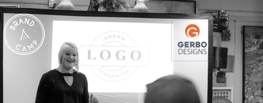 Photo of Sally Gerbo teaching class on Brands, Photo depicts instructor with students looking at a screen.